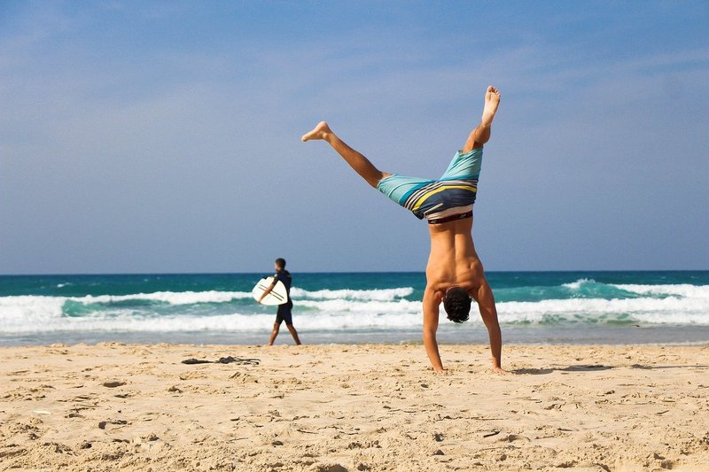 Mężczyzna stojący na rekach na plaży