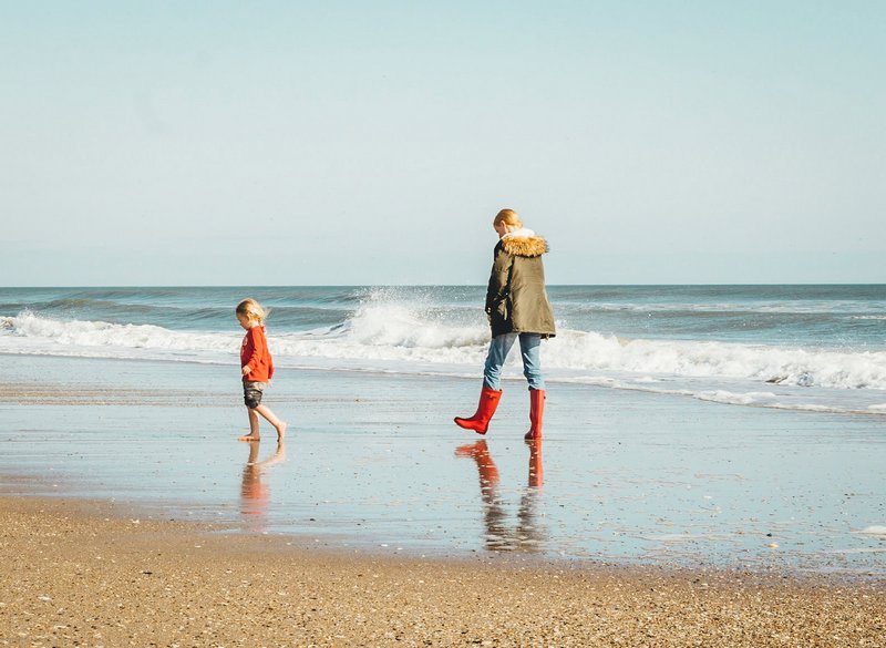 Mama i córka spacerujące po plaży
